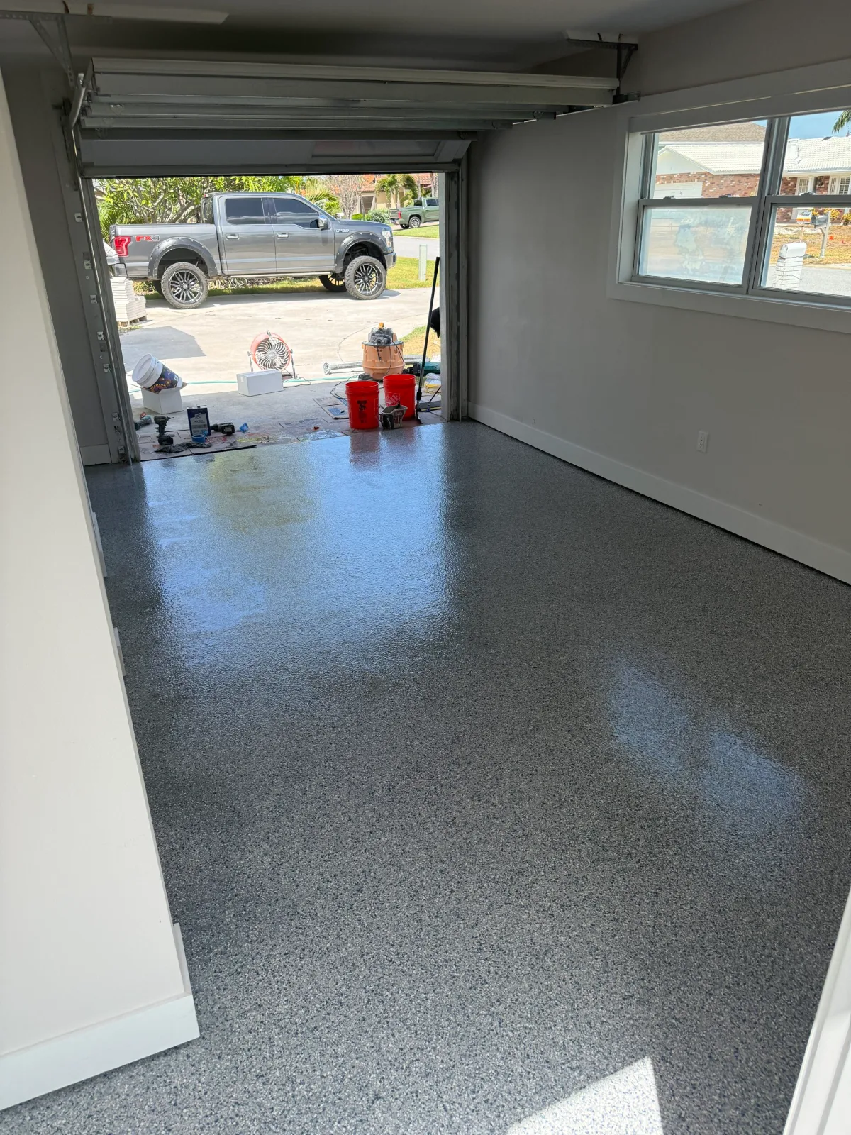 Finished full-flake garage floor coating by Suncoast Floor Coatings, view through open garage door in Pinellas County FL