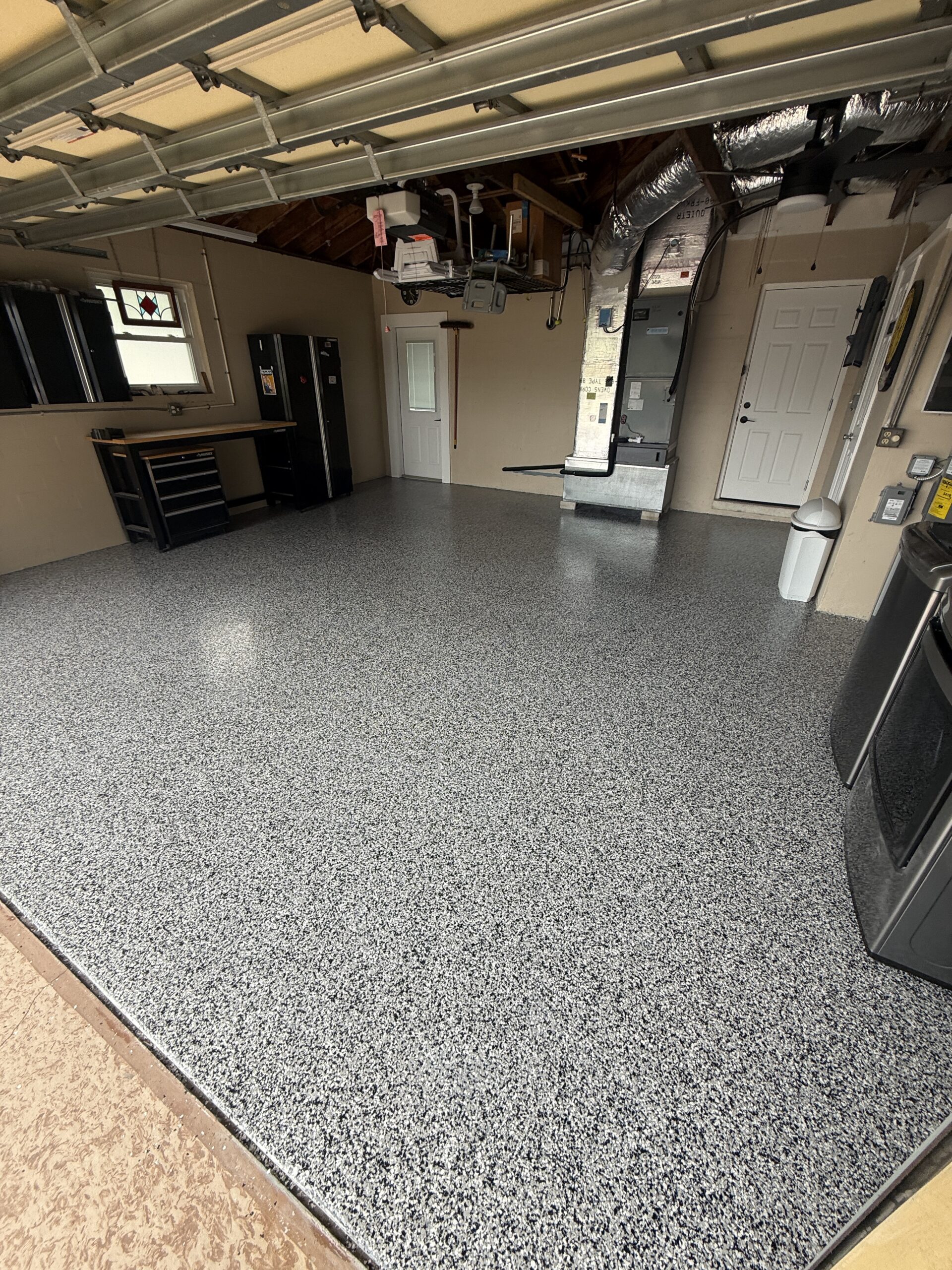 Freshly completed gray full-flake garage floor coating in a residential garage